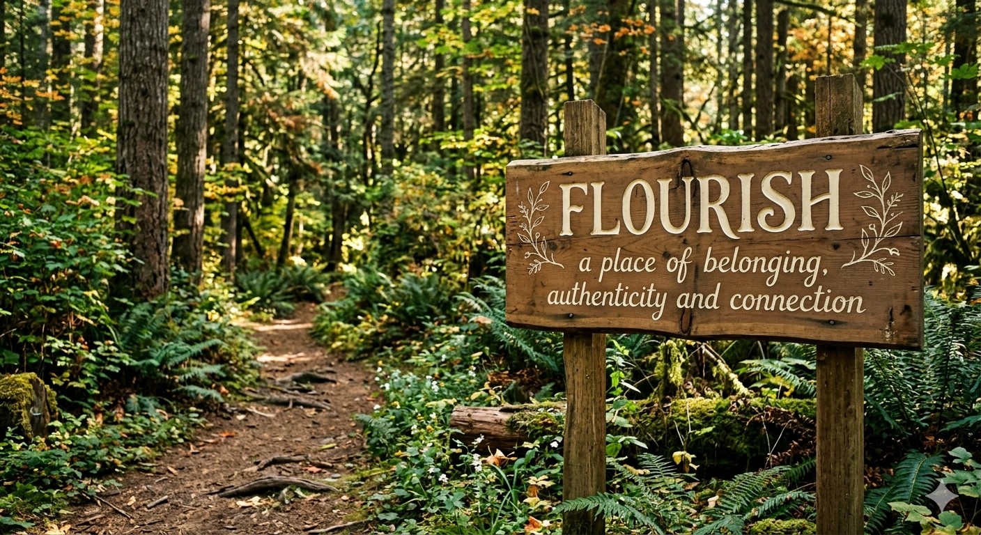 A wooden sign along a forest trail reading Flourish: a place of belonging, authenticity and connection.