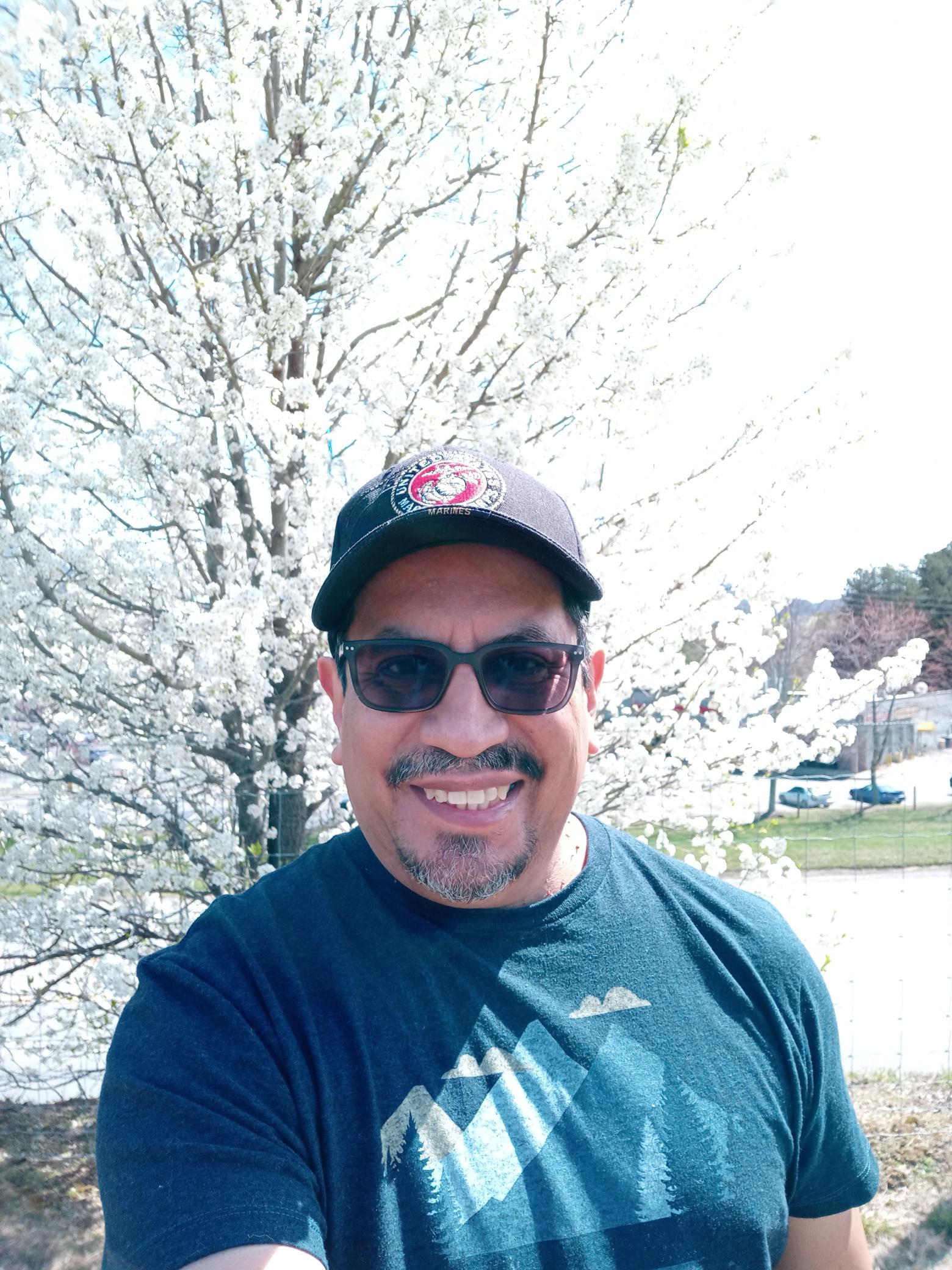 Pastor Francisco Gonzalez outdoors, smiling, wearing sunglasses.